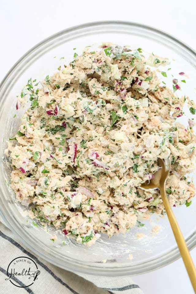 Salmon salad after being mixed together in a large glass bowl.