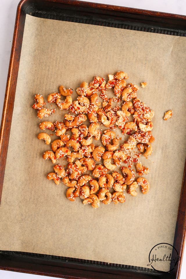 Cashews coated with the sauce before being toasted.