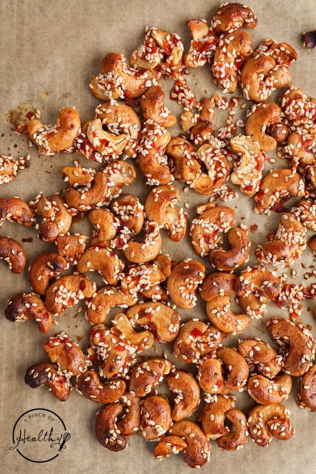 Cashews after being sauced and toasted on a baking sheet.