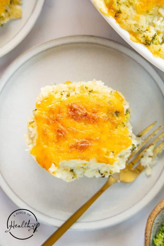 Single serving of broccoli rice casserole on a plate with a fork.