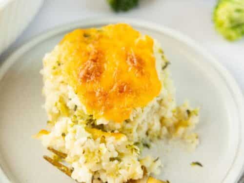 Broccoli Rice Casserole on a white plate with a gold fork.
