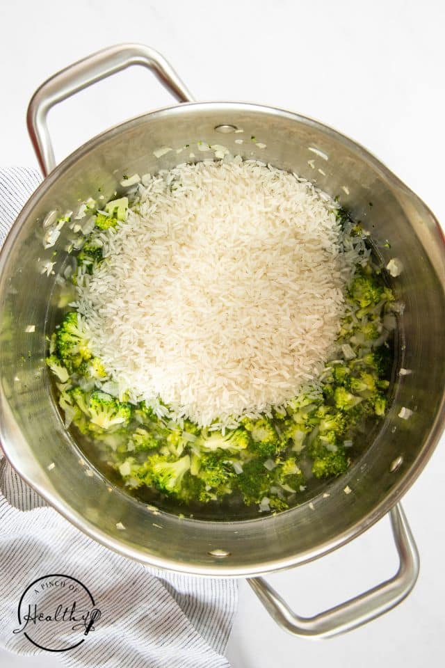 Broccoli and rice in a pan before liquids are added.