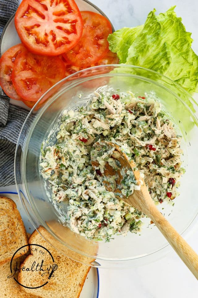Chicken salad sandwich mix in a large glass bowl after being combined.