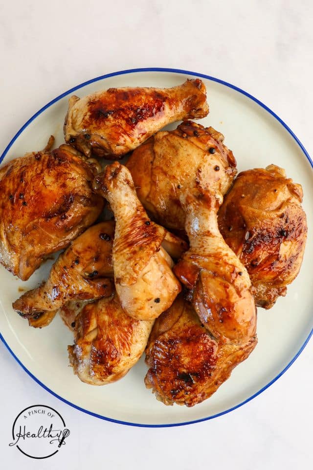 Seared chicken pieces for chicken adobo on a platter while the sauce is being made.
