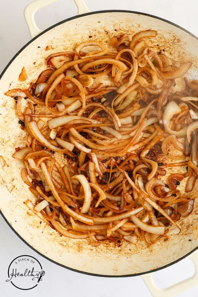 Onion for chicken adobo sauce in the skillet after being cooked.