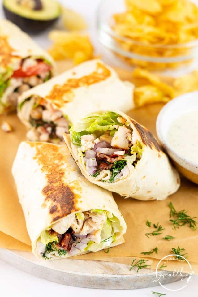 Chicken ranch wraps on a tray after being grilled and sliced in half.