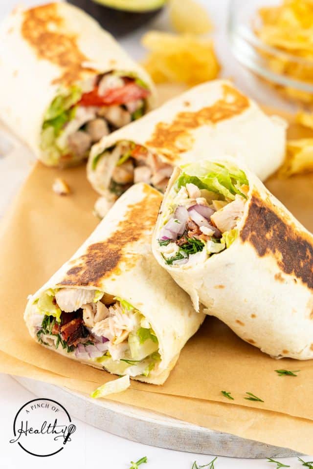 Chicken ranch wraps sliced in half on a tray.