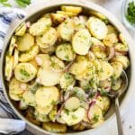 German potato salad in a large bowl with a serving spoon.