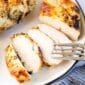 Sliced, cooked marinated chicken on a white plate with a fork.
