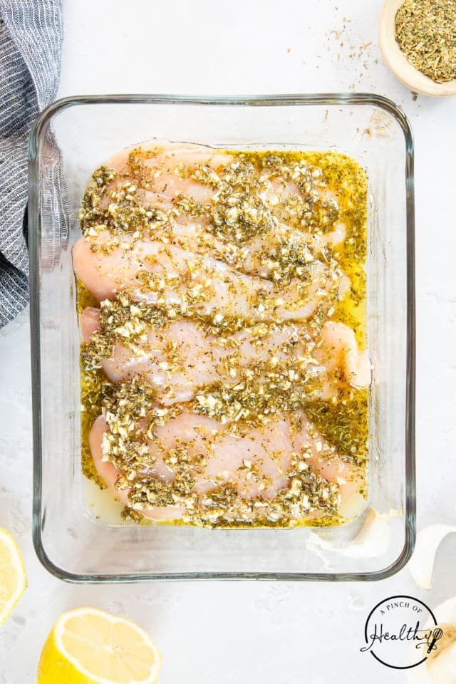 Marinated chicken in a glass container.