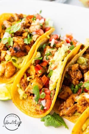 Grilled Chicken Street Tacos on a platter with tomatoes and cilantro.