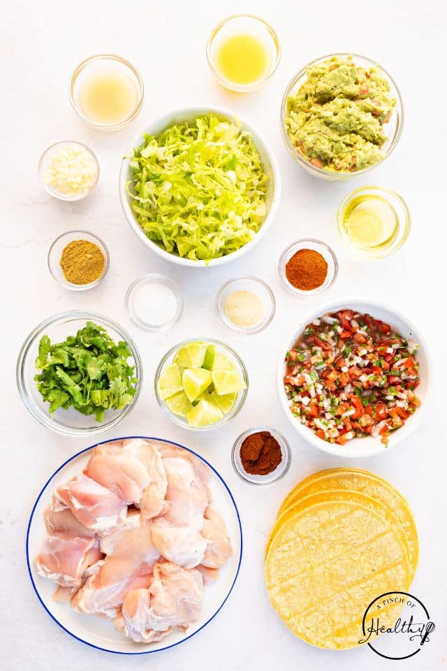 Ingredients for grilled chicken street tacos in separate containers.