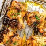 Cooked butterflied chicken legs on a wire rack.